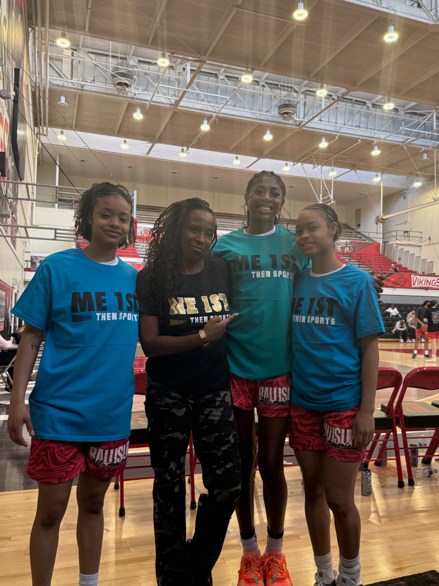 Athletes and coach wearing Me 1st Then Sports shirts courtside