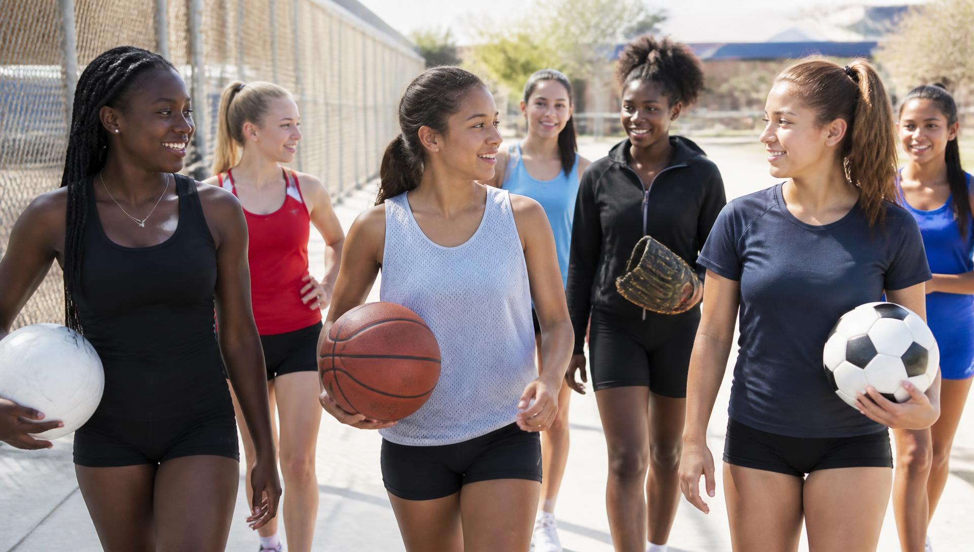 Middle and high school girls from basketball, volleyball, track, soccer, softball and flag football walking and talking together outdoors in Pasadena